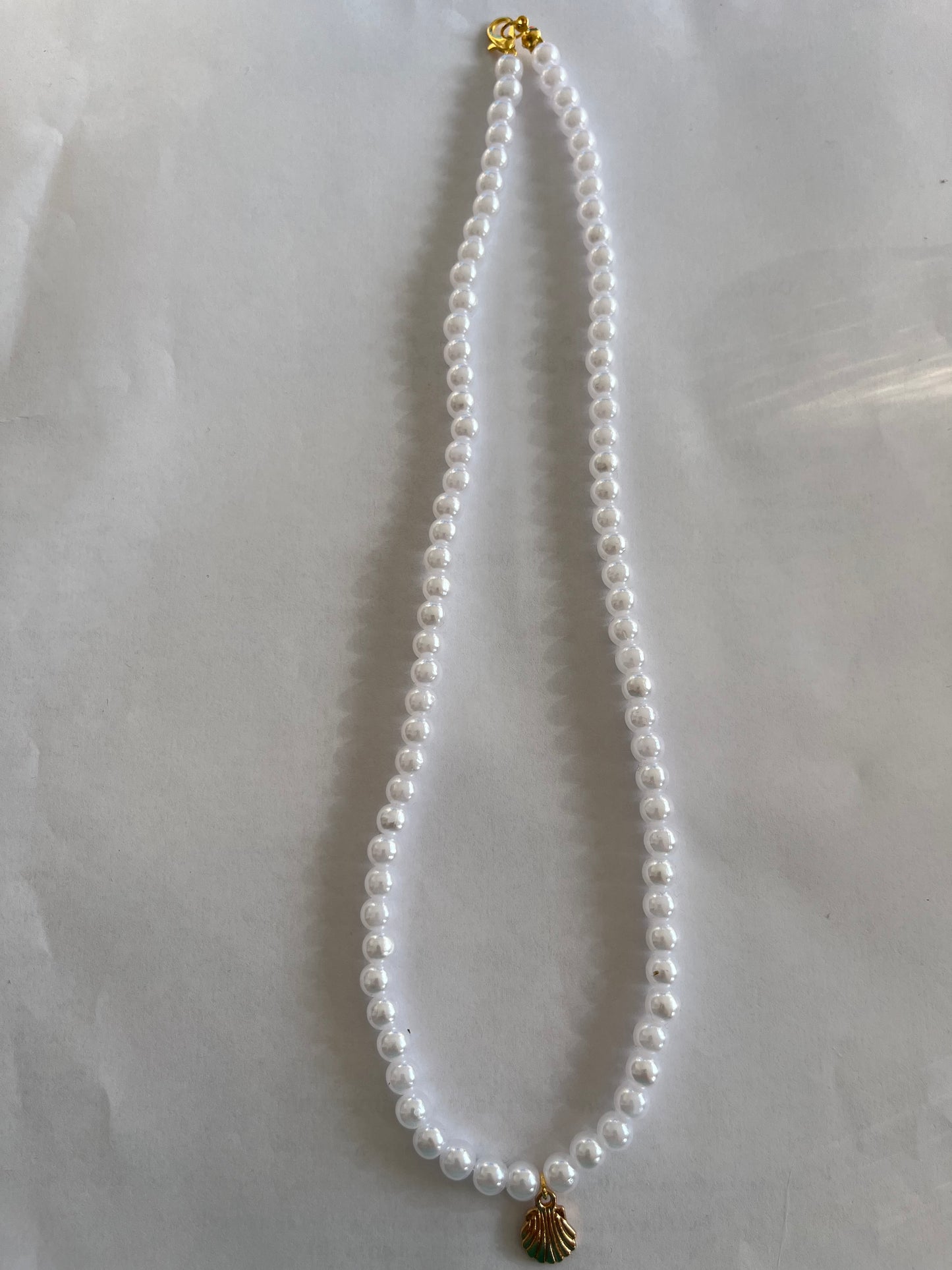 Pearl necklace with a small shell charm