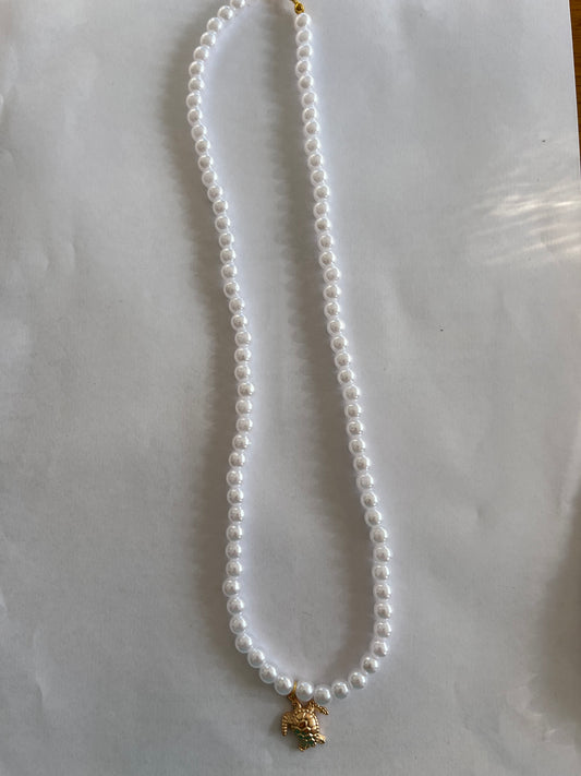 White pearl necklace with a turtle charm