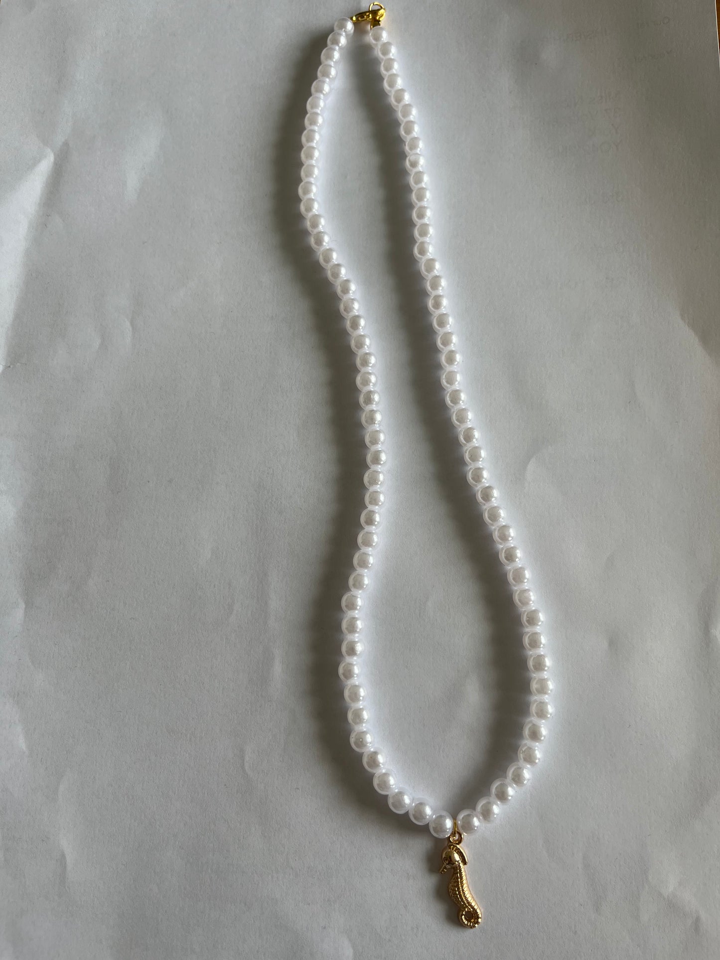White pearl necklace with a seahorse charm