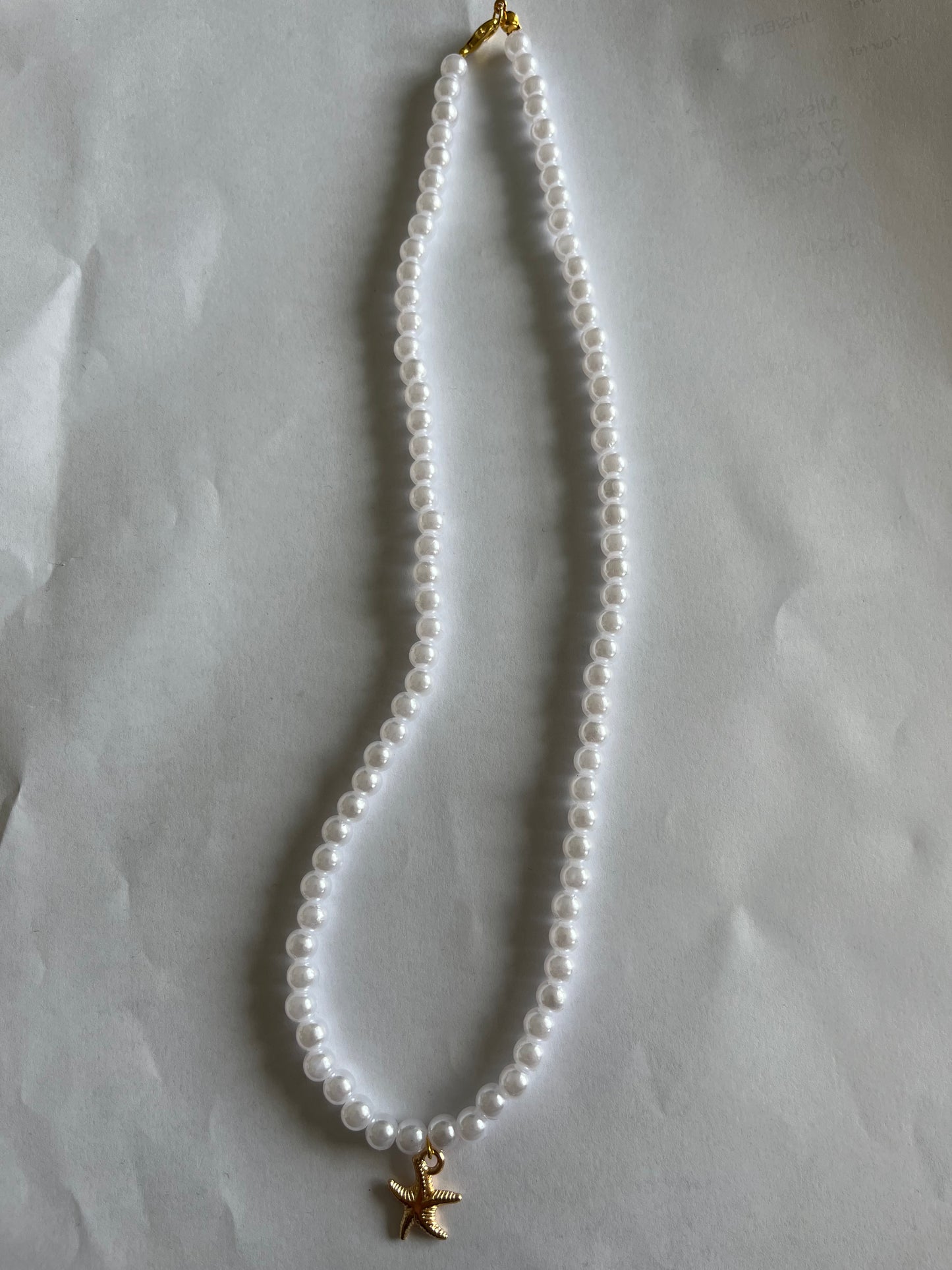 White pearl necklace with a starfish charm
